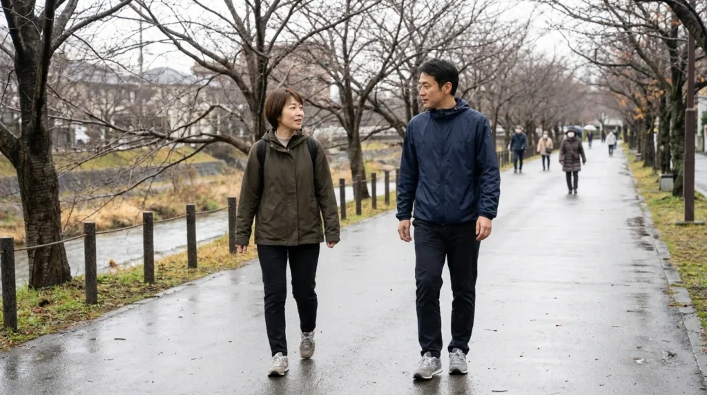 近所の川沿いを歩きながら会話する40代の日本人夫婦
